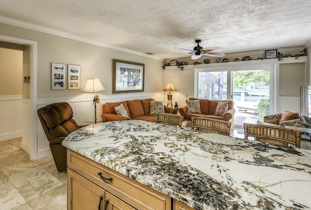 interior space with ceiling fan, crown molding, light stone countertops, and a textured ceiling