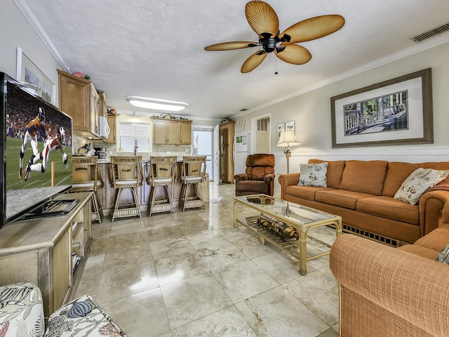 living room with crown molding, a textured ceiling, and ceiling fan