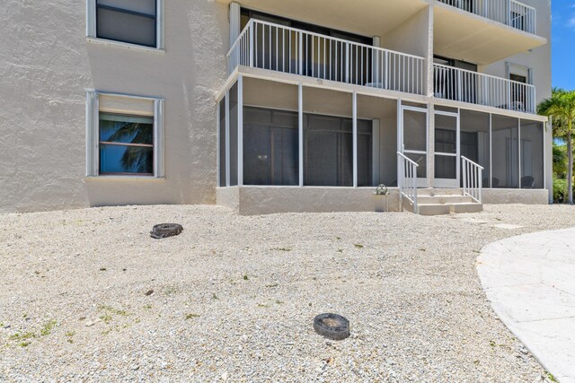 2000 Coco Plum Dr Unit 106, Marathon, FL 33050 - back of property featuring stucco siding, a sunroom, and a balcony