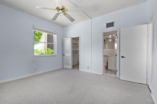 2000 Coco Plum Dr Unit 106, Marathon, FL 33050 - unfurnished bedroom featuring carpet flooring, a spacious closet, a textured ceiling, a closet, and ensuite bathroom