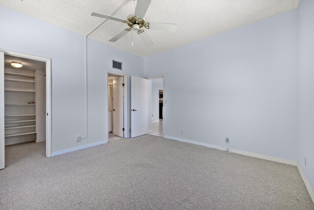 2000 Coco Plum Dr Unit 106, Marathon, FL 33050 - unfurnished bedroom with light colored carpet, a spacious closet, a textured ceiling, a closet, and a ceiling fan
