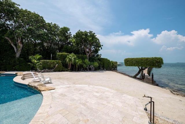 view of swimming pool with a patio area and a water view