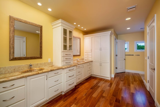 bathroom featuring hardwood / wood-style flooring, vanity, and backsplash