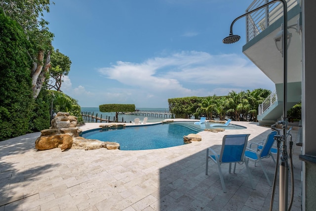 view of pool with an in ground hot tub, a patio, and a water view