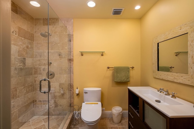 bathroom with toilet, vanity, tile patterned floors, and a shower with shower door