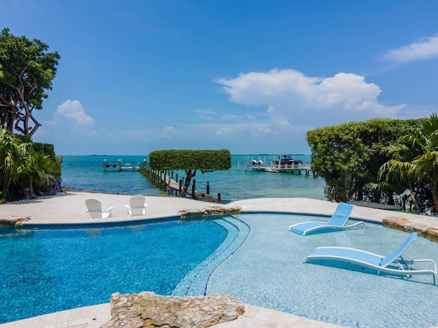 view of swimming pool featuring a boat dock and a water view