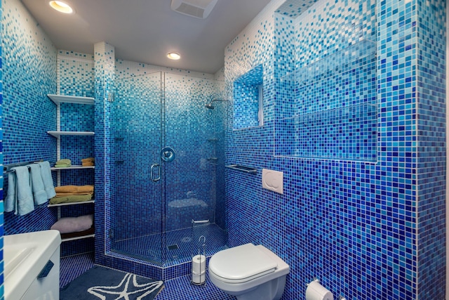 bathroom with toilet, tile walls, tile patterned floors, and a shower with shower door