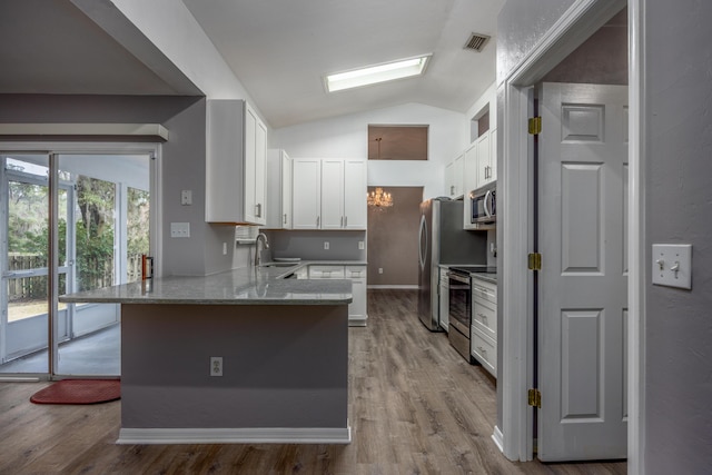 kitchen with stainless steel appliances, visible vents, white cabinets, a sink, and a peninsula