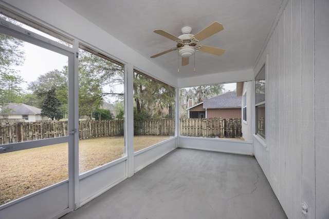 unfurnished sunroom with ceiling fan