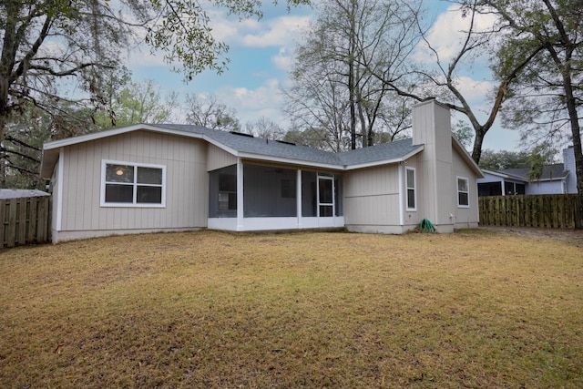 back of property with fence private yard, a shingled roof, a sunroom, a yard, and a chimney