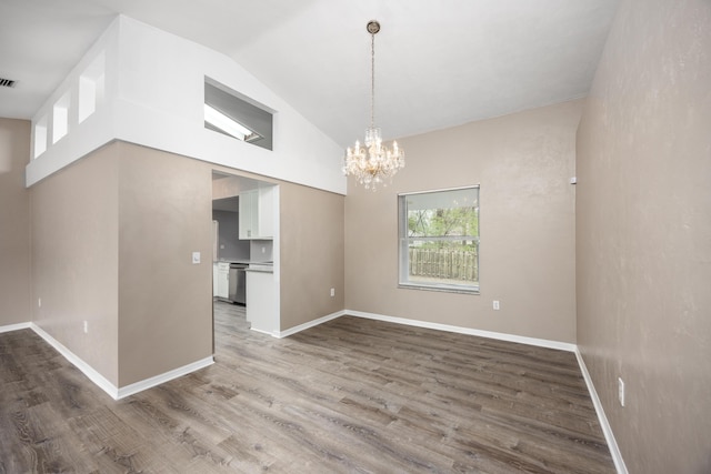 unfurnished dining area with baseboards, visible vents, a chandelier, wood finished floors, and high vaulted ceiling