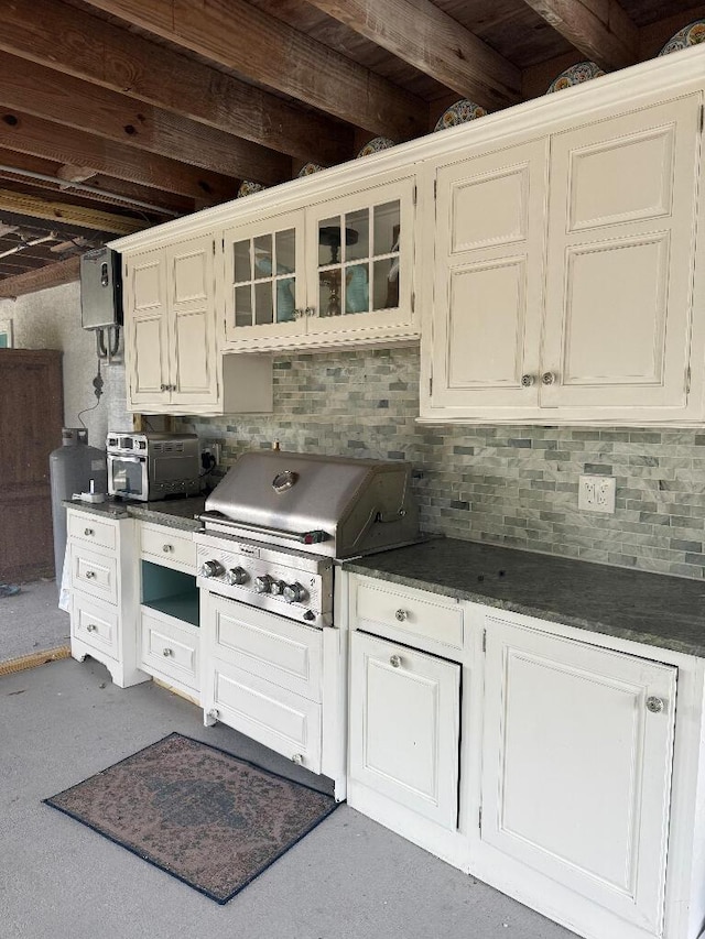 1672 Pandorea Ln, Big Pine, FL 33043 - kitchen featuring dark countertops, decorative backsplash, glass insert cabinets, and white cabinetry