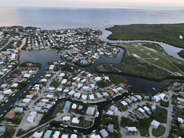 aerial view at dusk featuring a water view