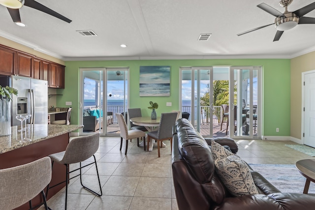 living room featuring plenty of natural light, ornamental molding, and light tile patterned flooring