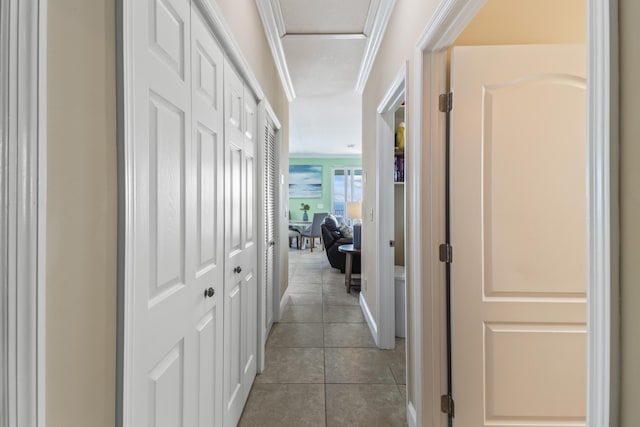 hall with light tile patterned floors and ornamental molding
