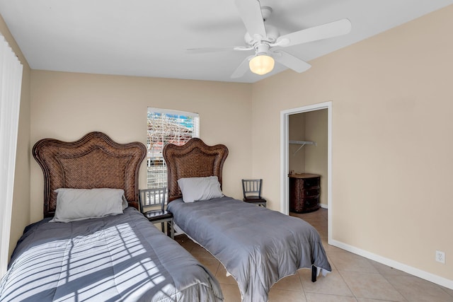 bedroom with light tile patterned flooring, ceiling fan, a spacious closet, and a closet