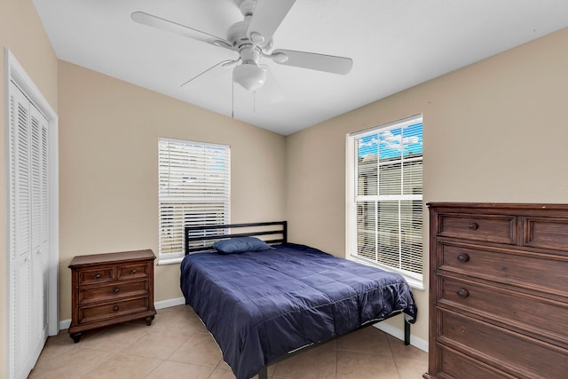 tiled bedroom featuring ceiling fan, vaulted ceiling, and a closet