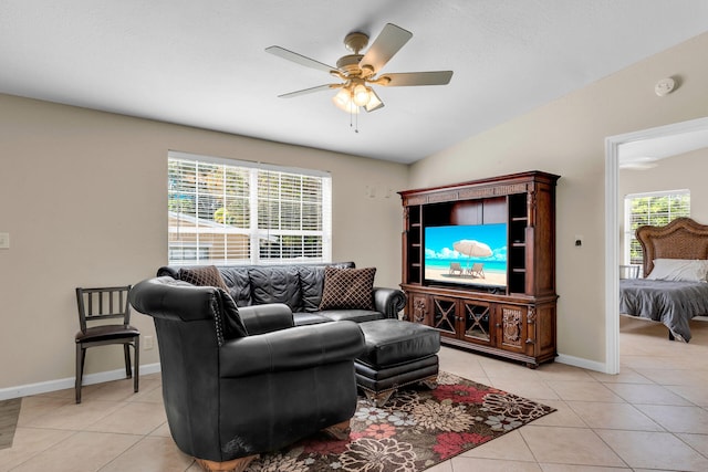 tiled living room featuring lofted ceiling, ceiling fan, and a healthy amount of sunlight