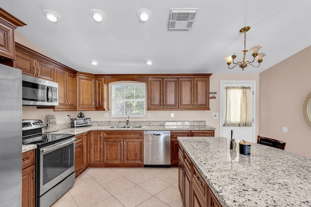 kitchen featuring light tile patterned flooring, sink, light stone counters, hanging light fixtures, and stainless steel appliances