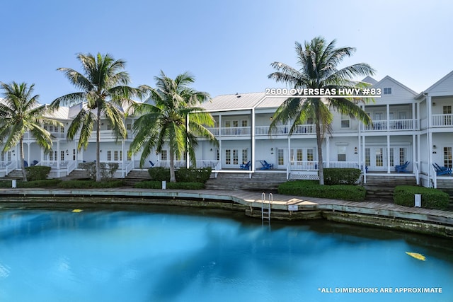 view of pool with french doors and a water view