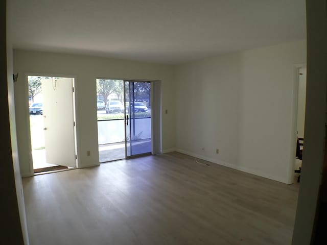 unfurnished room featuring baseboards and wood finished floors