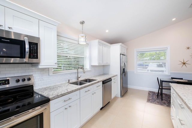 453 Lime Dr, Key Largo, FL 33037 - kitchen with stainless steel appliances, a sink, tasteful backsplash, vaulted ceiling, and white cabinetry