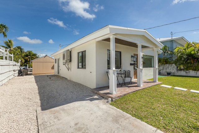 view of home's exterior with stucco siding, fence, a lawn, and a patio