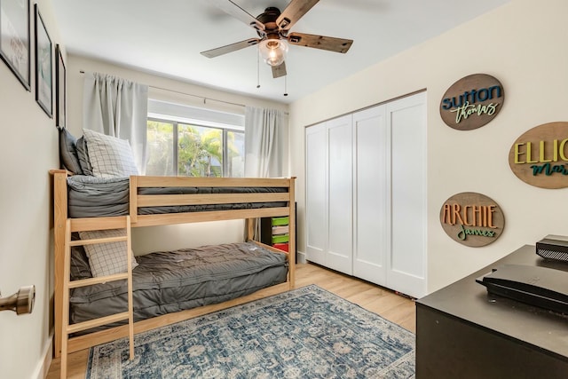 bedroom featuring light wood-style flooring, ceiling fan, and a closet