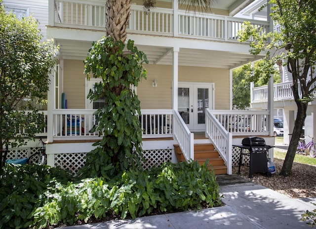 property entrance featuring a balcony and french doors