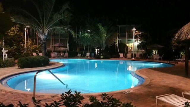 pool at twilight with a patio area