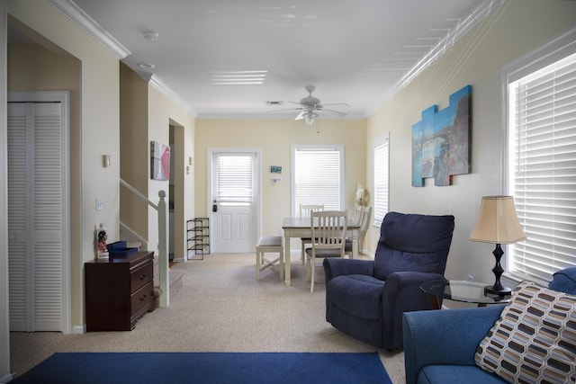 carpeted living room with crown molding and ceiling fan