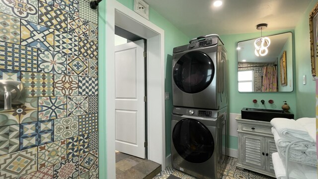 bathroom featuring stacked washer / drying machine and toilet