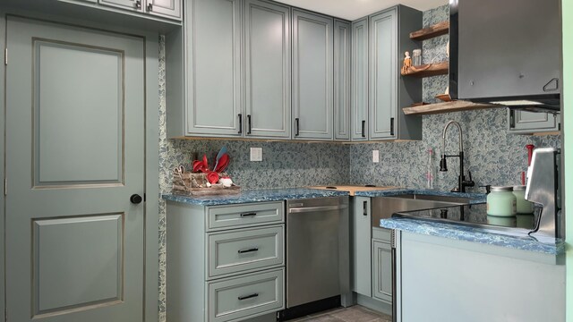 kitchen with appliances with stainless steel finishes, sink, gray cabinetry, and backsplash