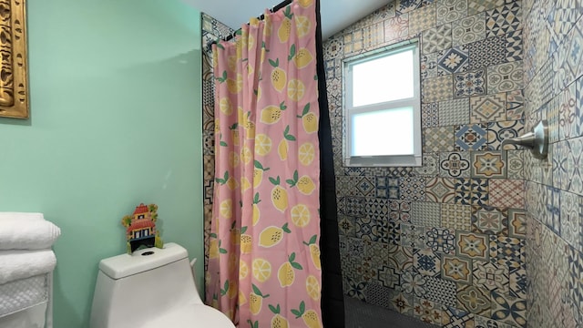 bathroom with toilet and a shower with shower curtain