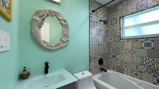 full bathroom with tiled shower / bath, vanity, and toilet