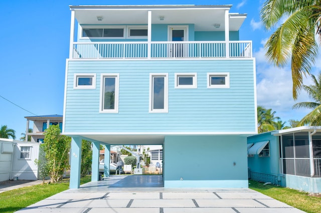 rear view of property featuring a balcony and a carport