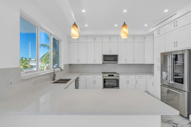 kitchen with sink, white cabinetry, backsplash, stainless steel appliances, and decorative light fixtures