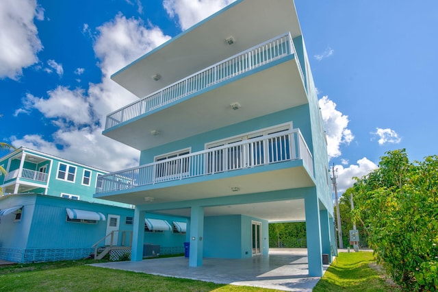 back of property with a balcony and a lawn