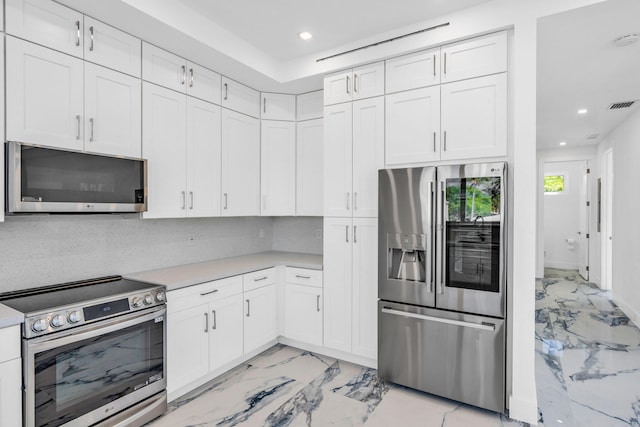 kitchen featuring backsplash, white cabinets, and appliances with stainless steel finishes