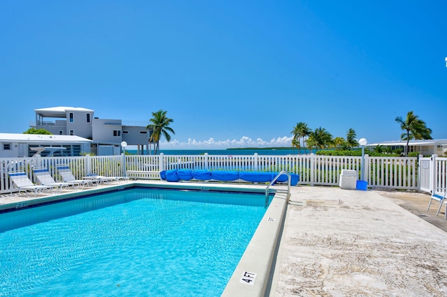 view of pool with a patio and a water view