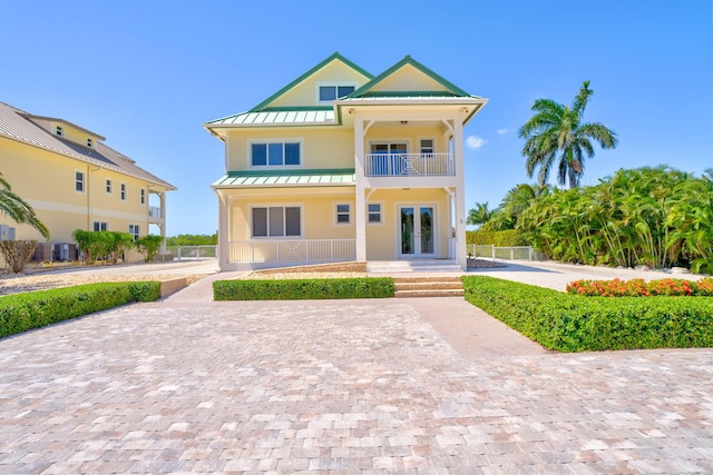 2394 Coco Plum Dr, Marathon, FL 33050 - view of front of home with a standing seam roof, a balcony, metal roof, and french doors