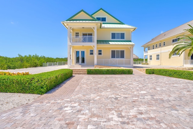 2394 Coco Plum Dr, Marathon, FL 33050 - view of front of house featuring a standing seam roof, a balcony, metal roof, covered porch, and french doors