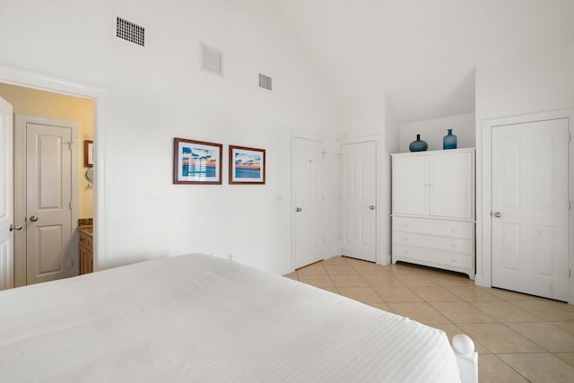 tiled bedroom with multiple closets and high vaulted ceiling