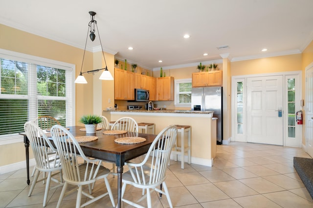 tiled dining room featuring ornamental molding and sink