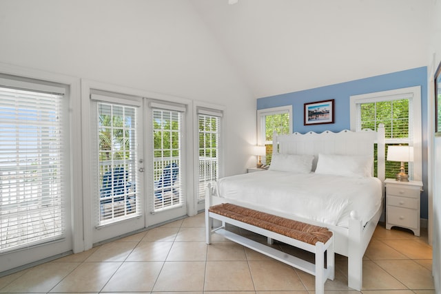 tiled bedroom with multiple windows, access to outside, high vaulted ceiling, and french doors