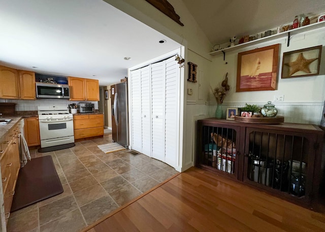 2 Riviera Dr, Big Coppitt, FL 33040 - kitchen with dark wood-style flooring, a sink, decorative backsplash, appliances with stainless steel finishes, and dark countertops