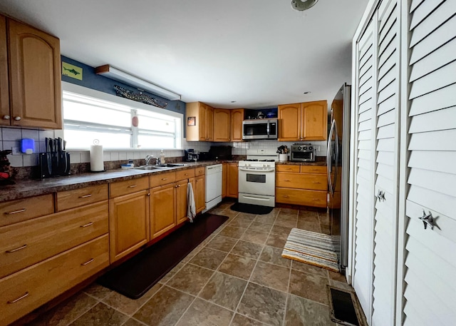 2 Riviera Dr, Big Coppitt, FL 33040 - kitchen featuring dark countertops, decorative backsplash, stainless steel appliances, and a sink