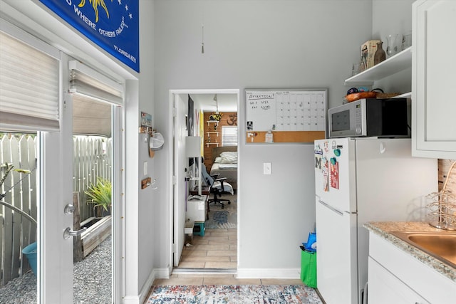 kitchen featuring a healthy amount of sunlight, white cabinets, and white refrigerator