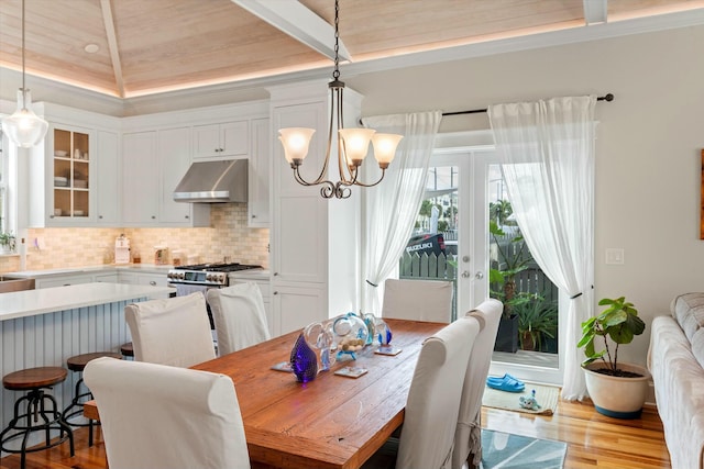 dining area with french doors, an inviting chandelier, and light wood-type flooring