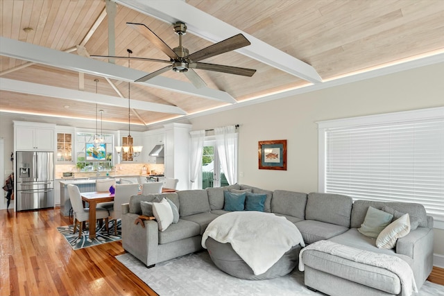 living room with wood ceiling, vaulted ceiling with beams, ceiling fan with notable chandelier, and light hardwood / wood-style flooring